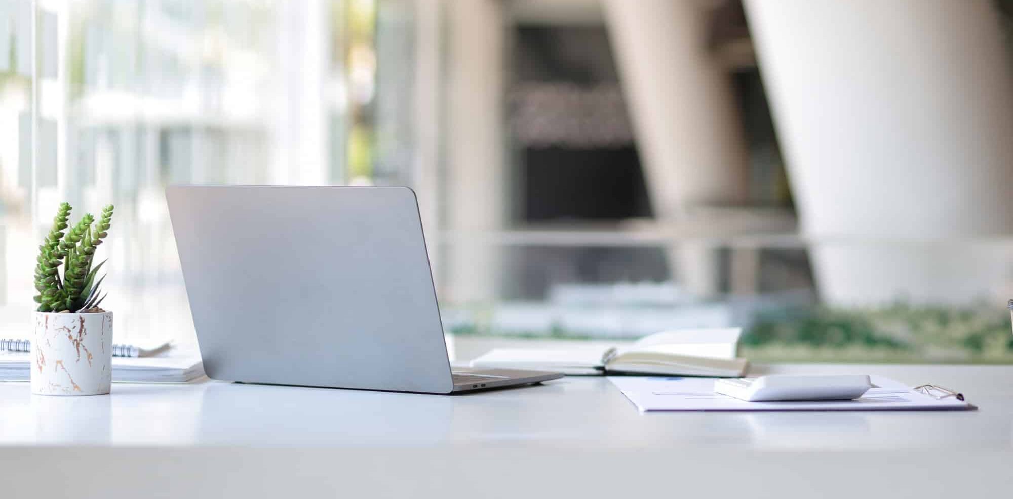 Laptop on a desk in an open financial office.